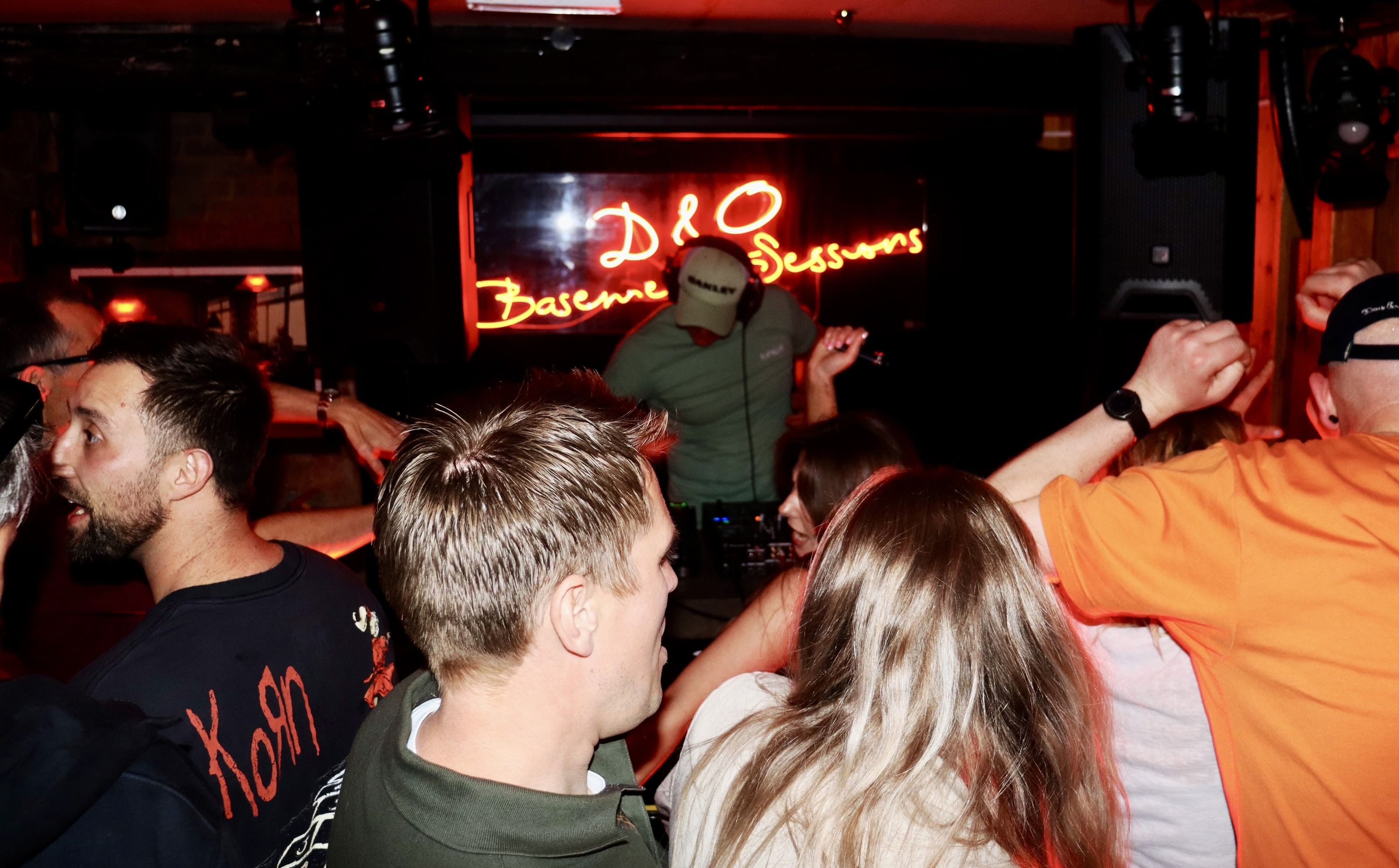 A packed basement crowd in front of the DJ booth at a RUN SY1 event