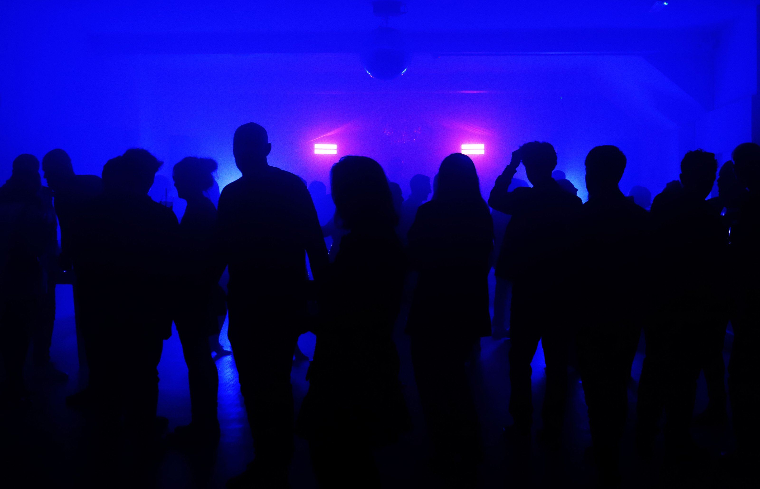The crowd in silhouette under blue lights at The Xmas Crackers, The Carlton, Newcastle-under-Lyme